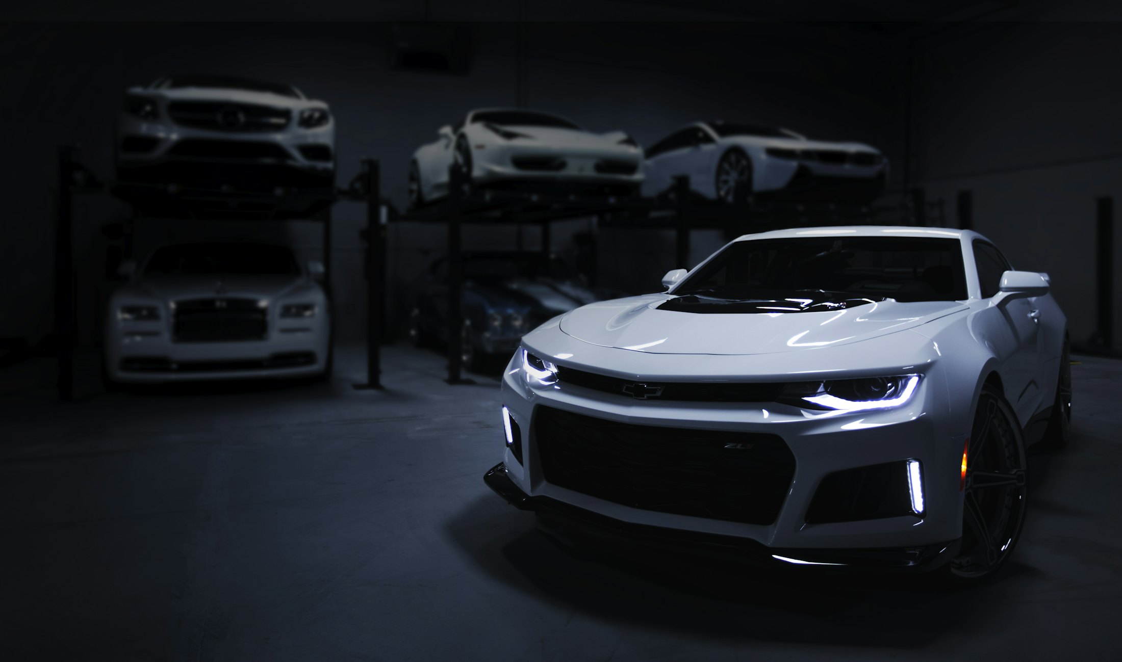 Atelier automobile plongé dans la pénombre, voiture de sport au premier plan